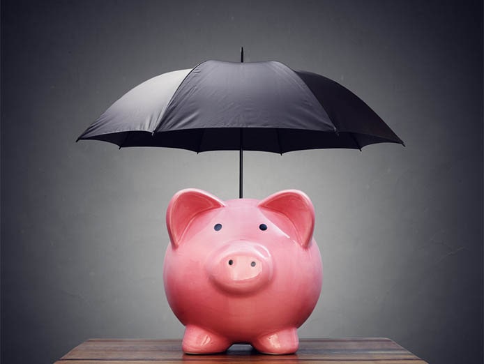 Pink piggy bank with a black open umbrella