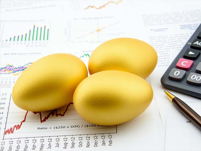 Three gold eggs on analytics reports near a calculator and pen