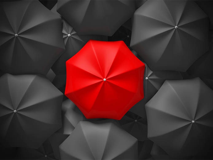 Black umbrellas opened and arranged with a red one at the middle