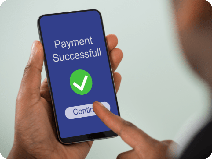 A person holding a phone which is showing payment successful